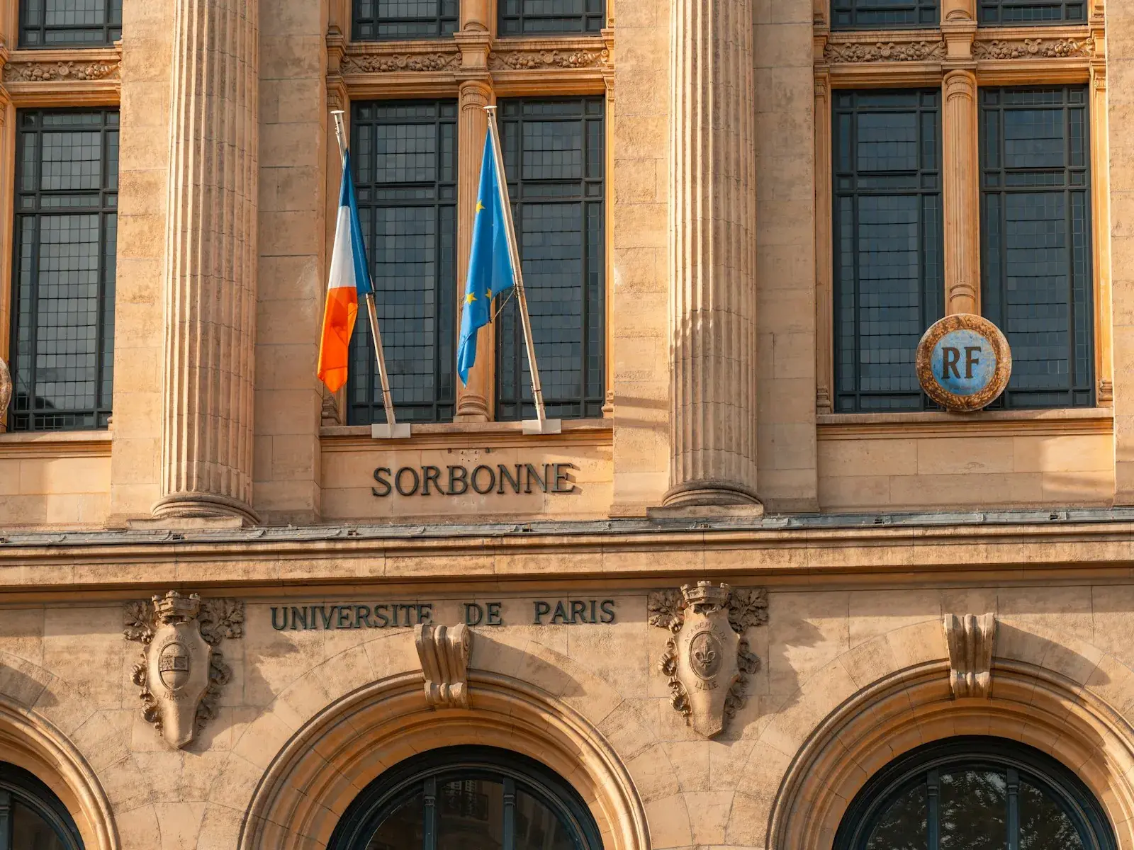 The Sorbonne university facade in Paris with French and European flags