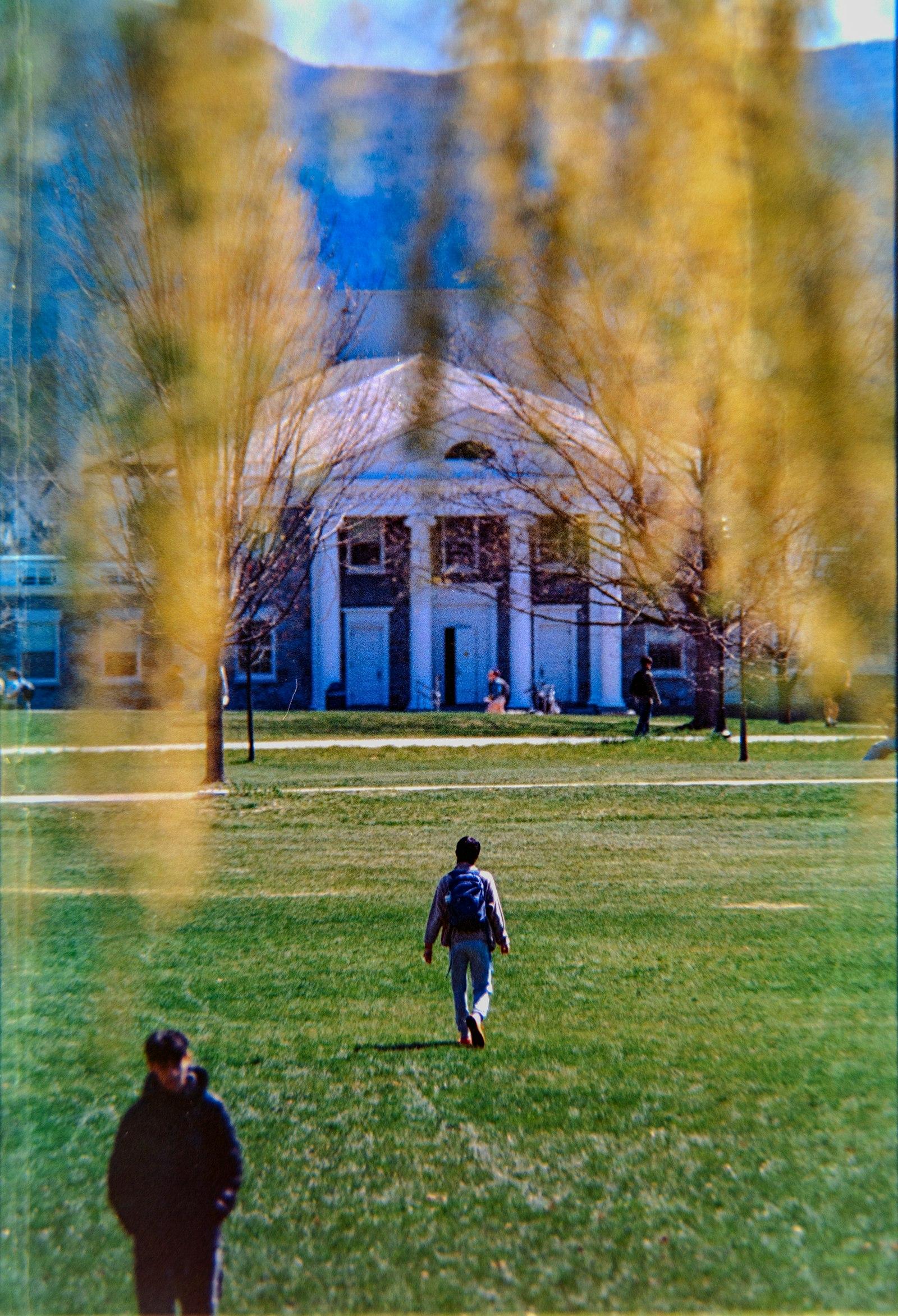 Students walking across a green university campus